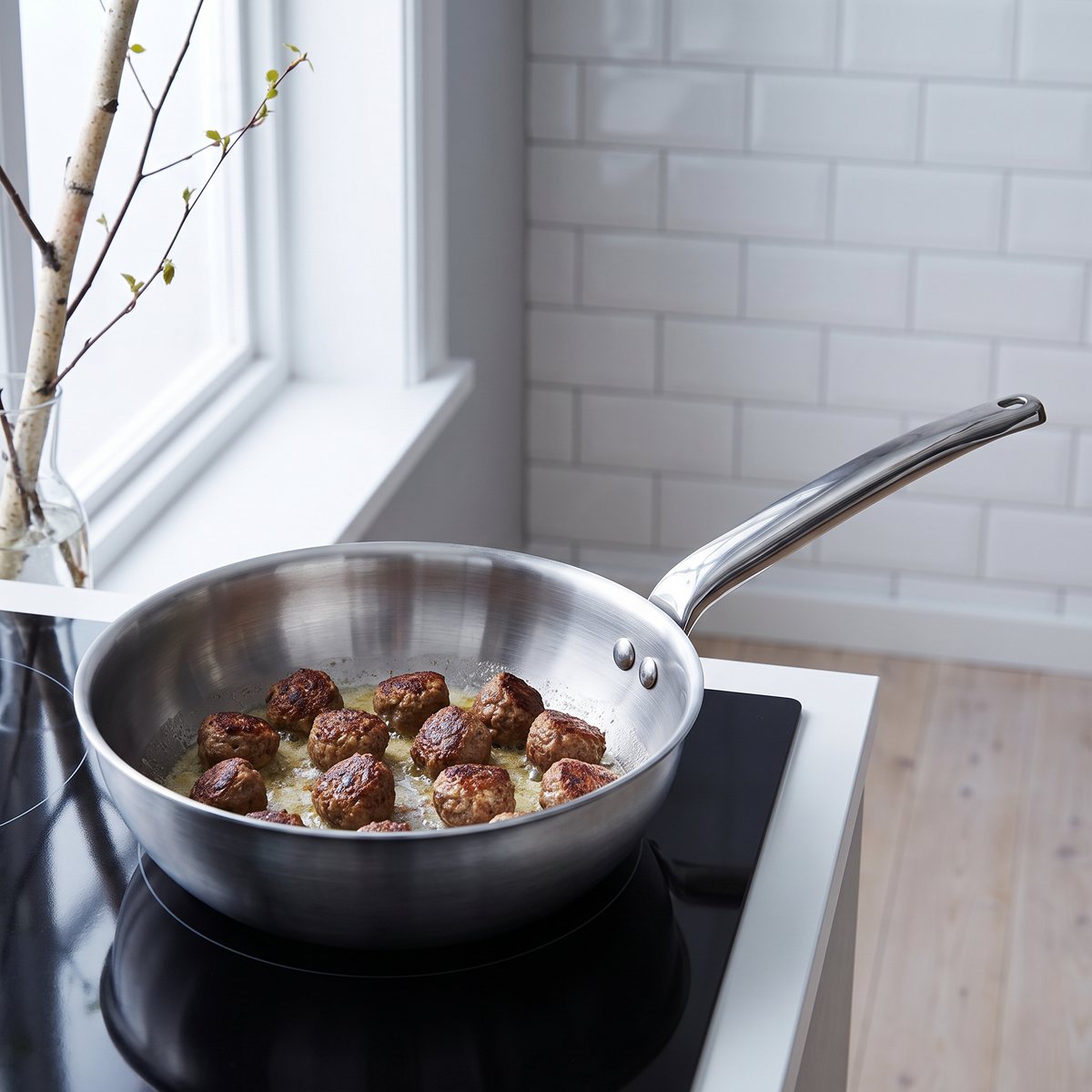 De Buyer Alchimy sauteuse med köttbullar på induktionshäll i ett svenskt kök