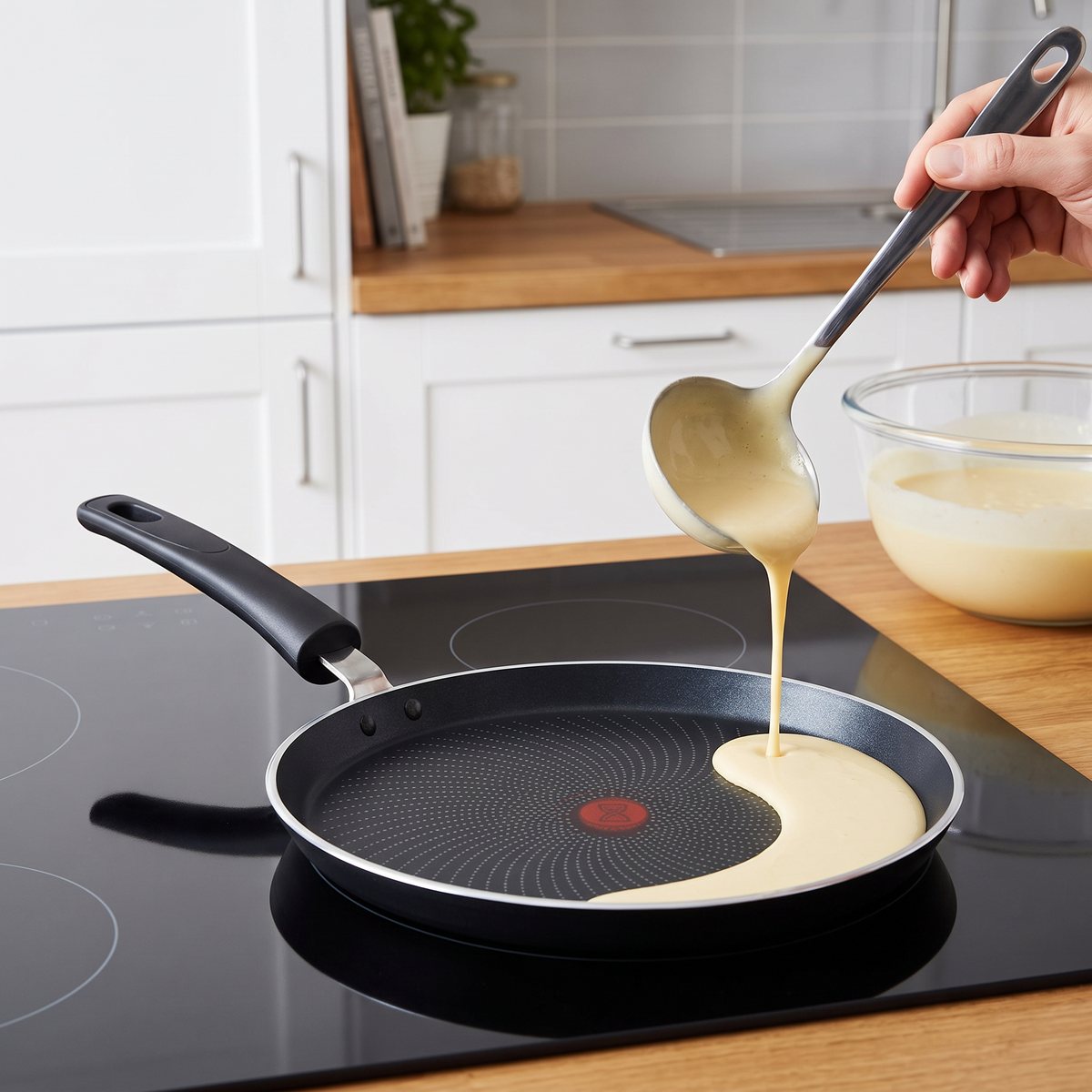 Tefal Start'Easy pannkakspanna med röd färgsignal i mitten när smet hälls i, på en induktionshäll i ett svenskt kök