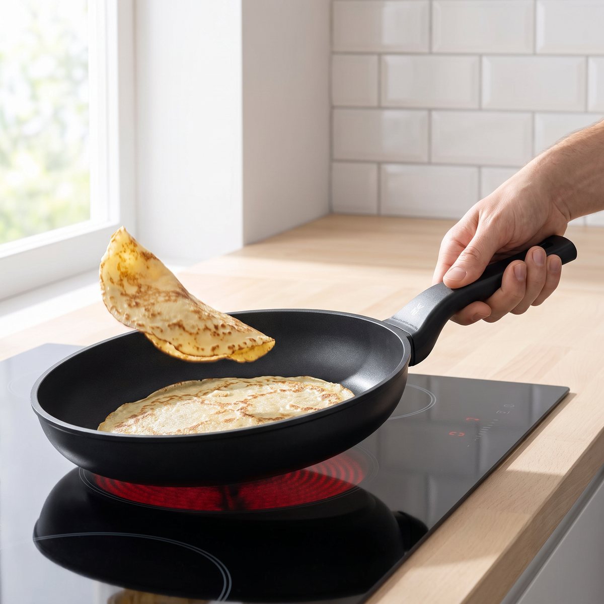 WMF PermaDur Excell-stekpanna med pannkaka på en häll i ett svenskt kök
