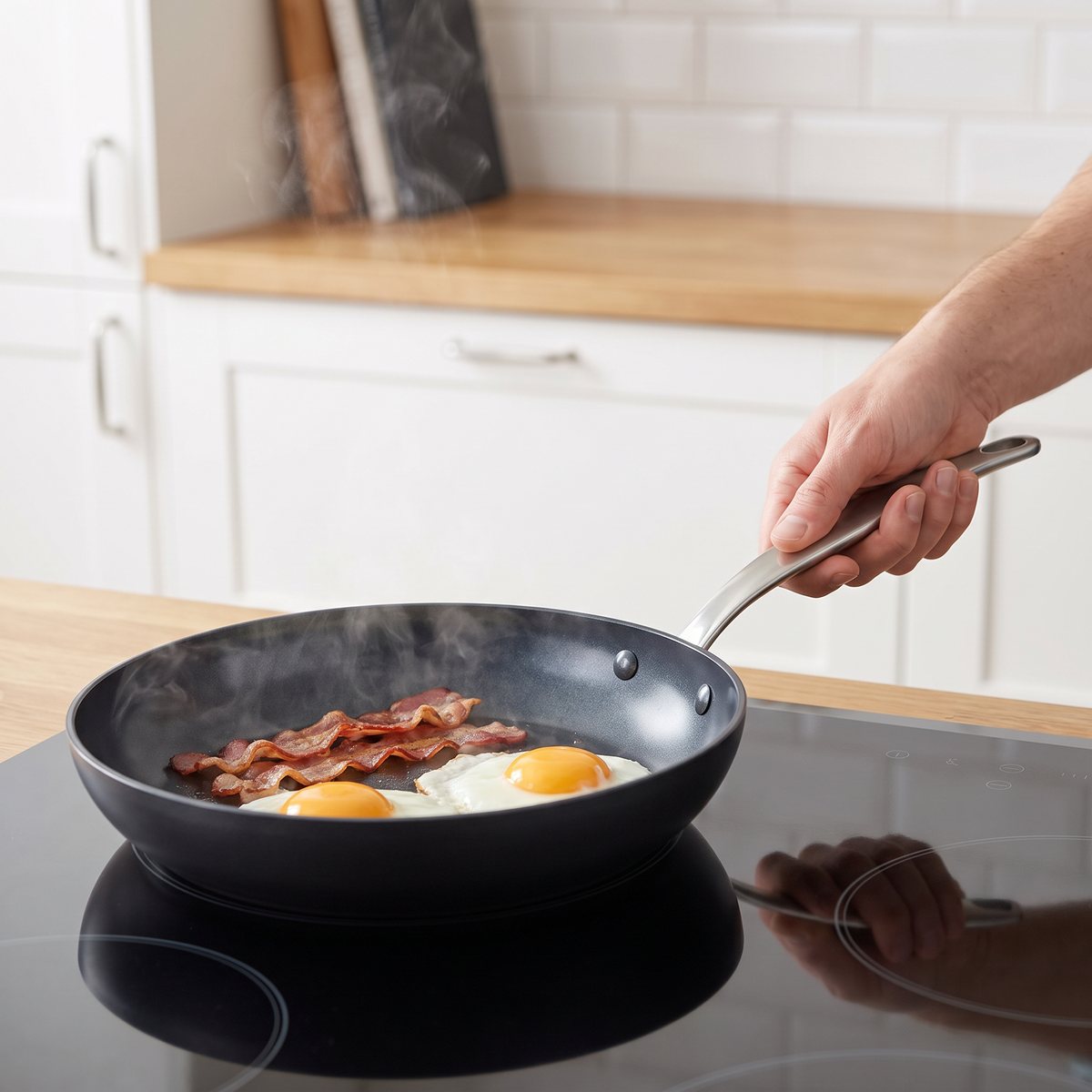 Greenpan Barcelona stekpanna med keramisk beläggning på en induktionshäll i ett svenskt kök, med stekta ägg och bacon