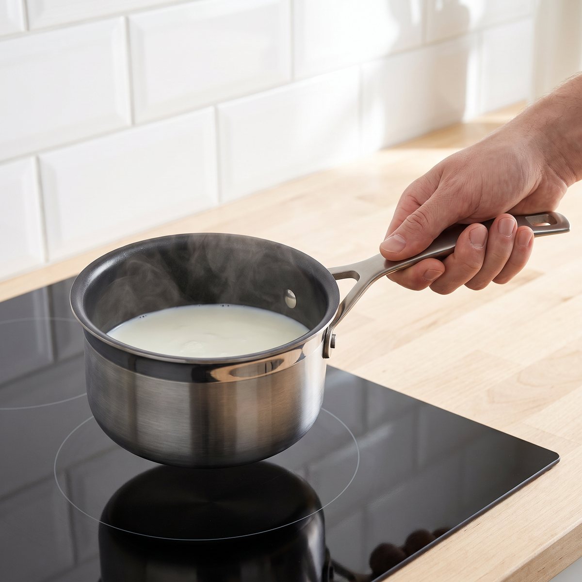 Le Creuset 3-Ply-kastrull med non-stick-insida som värmer mjölk på en induktionshäll i ett svenskt kök