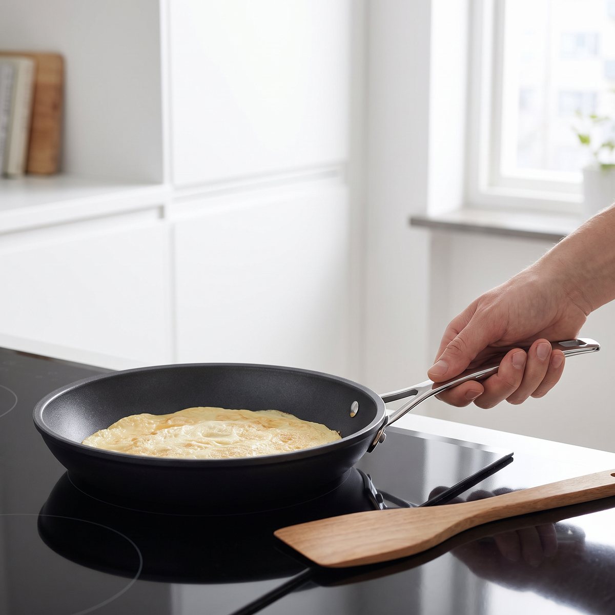 Le Creuset omelettpanna med non-stick-yta på induktionshäll i ett ljust svenskt kök