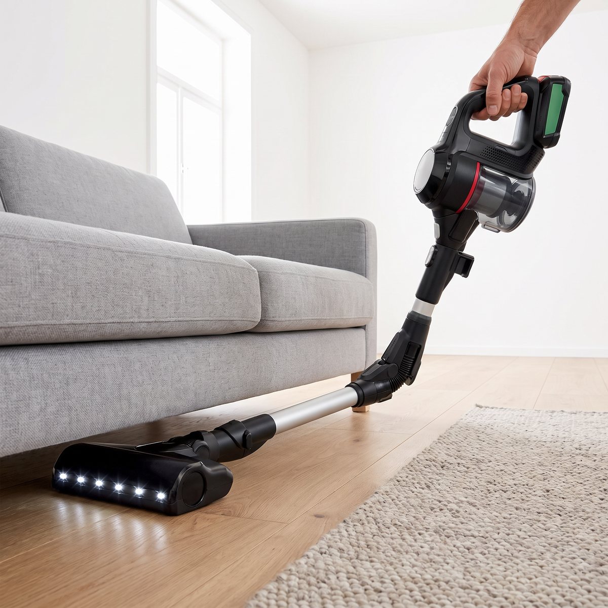 Bosch Unlimited 7 med böjt rör som når in under en grå soffa i ett svenskt vardagsrum