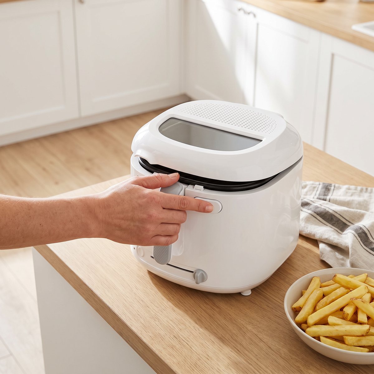 Vit Tefal Uno-fritös på en köksbänk i ett ljust svenskt kök med pommes frites