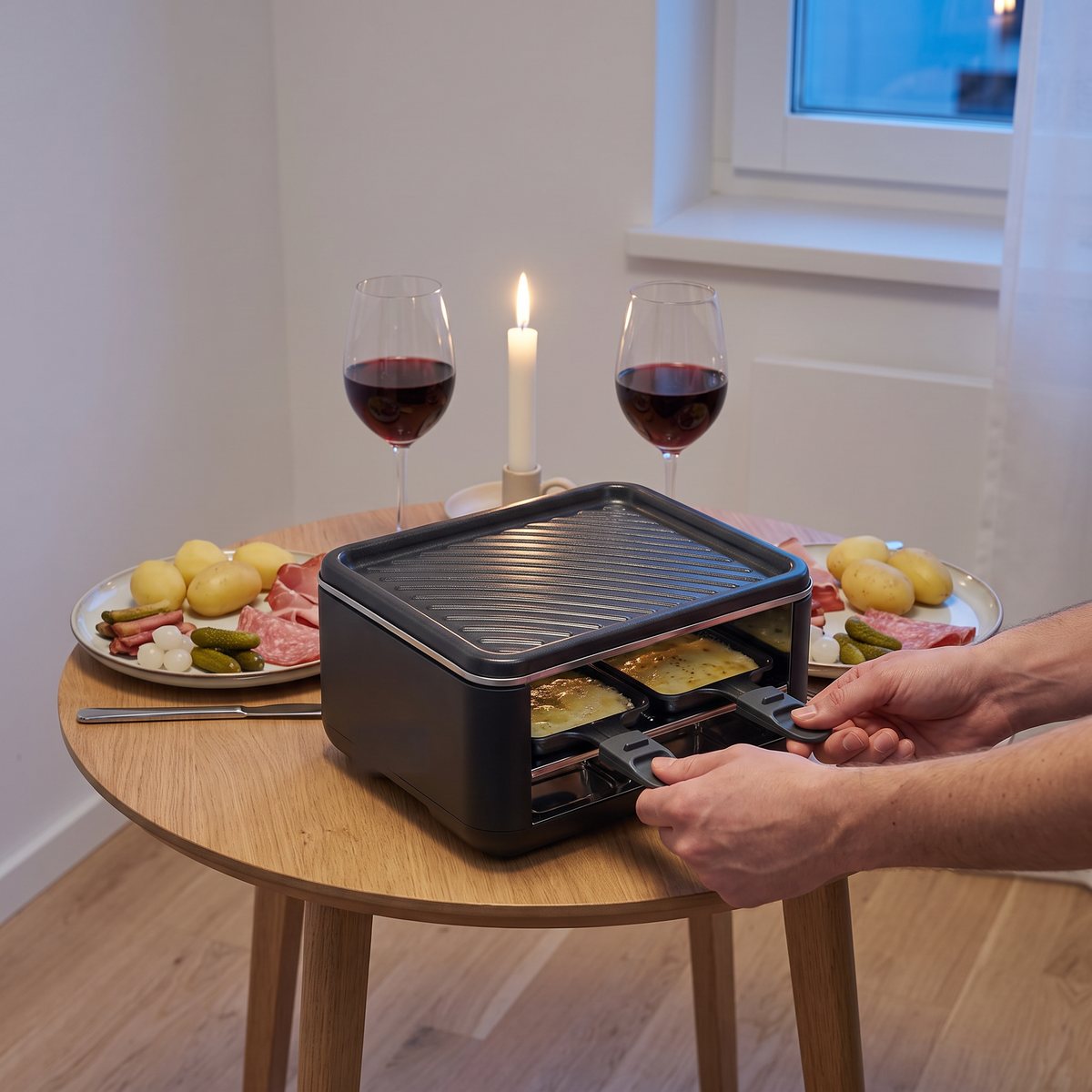 Severin Black Line Mini med ost i två pannor på ett litet runt bord i en svensk lägenhet
