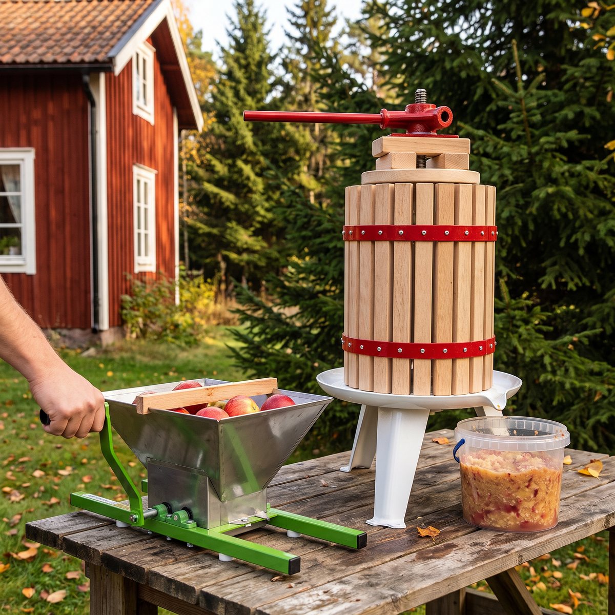 vidaXL frukt- och vinpress i trä tillsammans med handvevad fruktkross på ett arbetsbord vid ett rött svenskt trähus