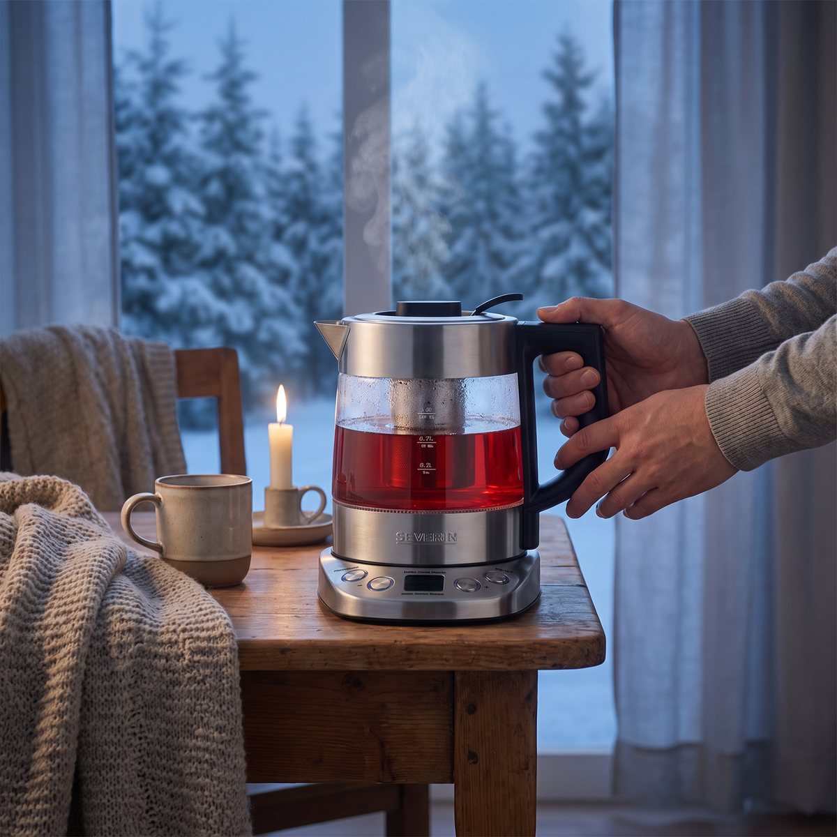 Severin WK 3473 Deluxe Mini med rött örtte vid ett fönster mot snöig granskog