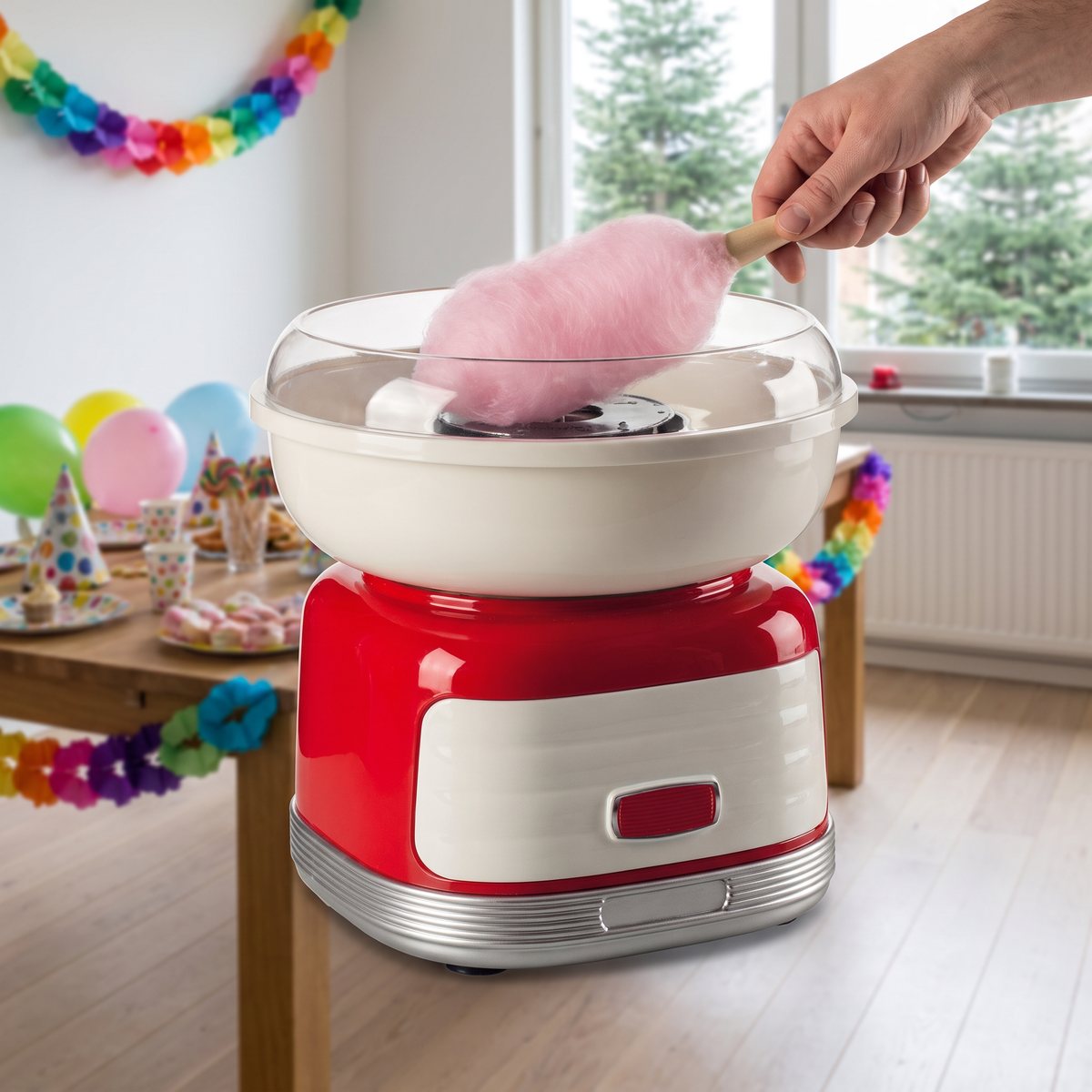 Röd retromaskin för sockervadd på ett kalasbord i ett svenskt vardagsrum