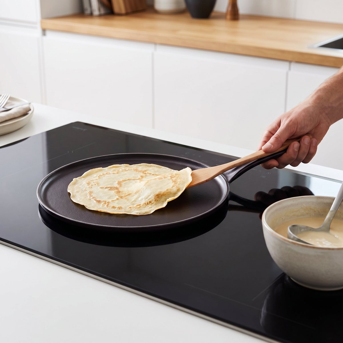 Le Creuset crepespanna i gjutjärn på en induktionshäll i ett svenskt kök med en crêpe i pannan