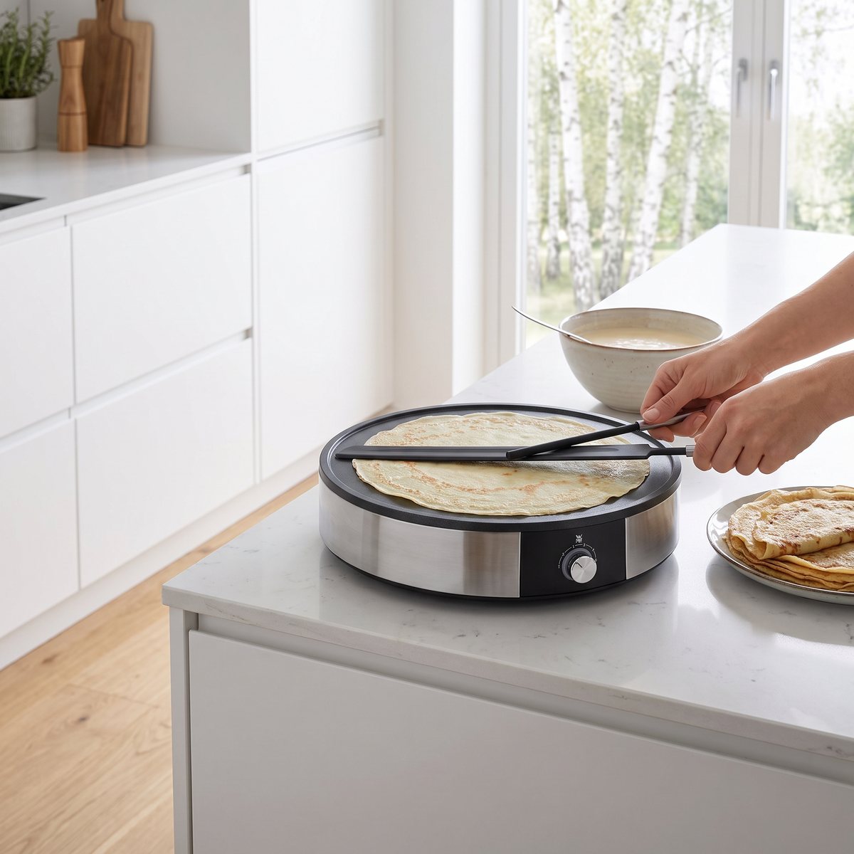 WMF Lono Crêperie på en köksbänk i ett svenskt kök där en tunn crêpe breds ut på plattan