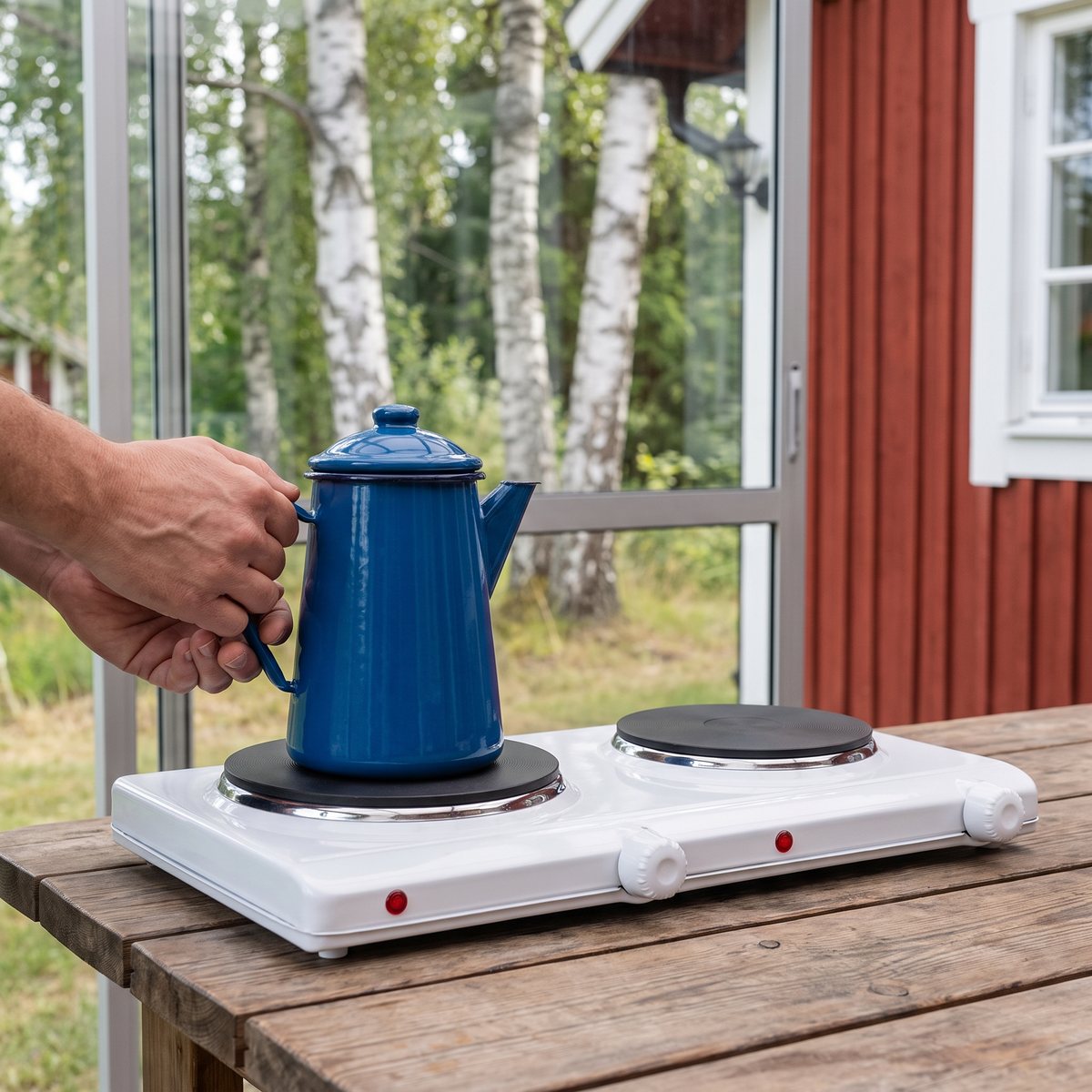 Vit Severin DK 1042 dubbel kokplatta på ett träbord i en glasveranda på en svensk stuga med en kaffepanna på plattan