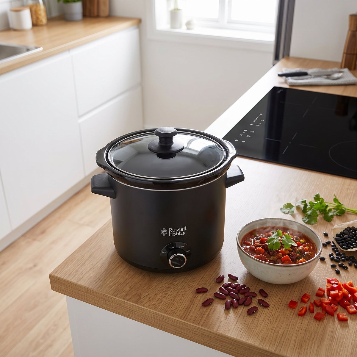 Russell Hobbs Chalkboard slow cooker i matt svart på en köksbänk i ett svenskt kök med en skål chili bredvid