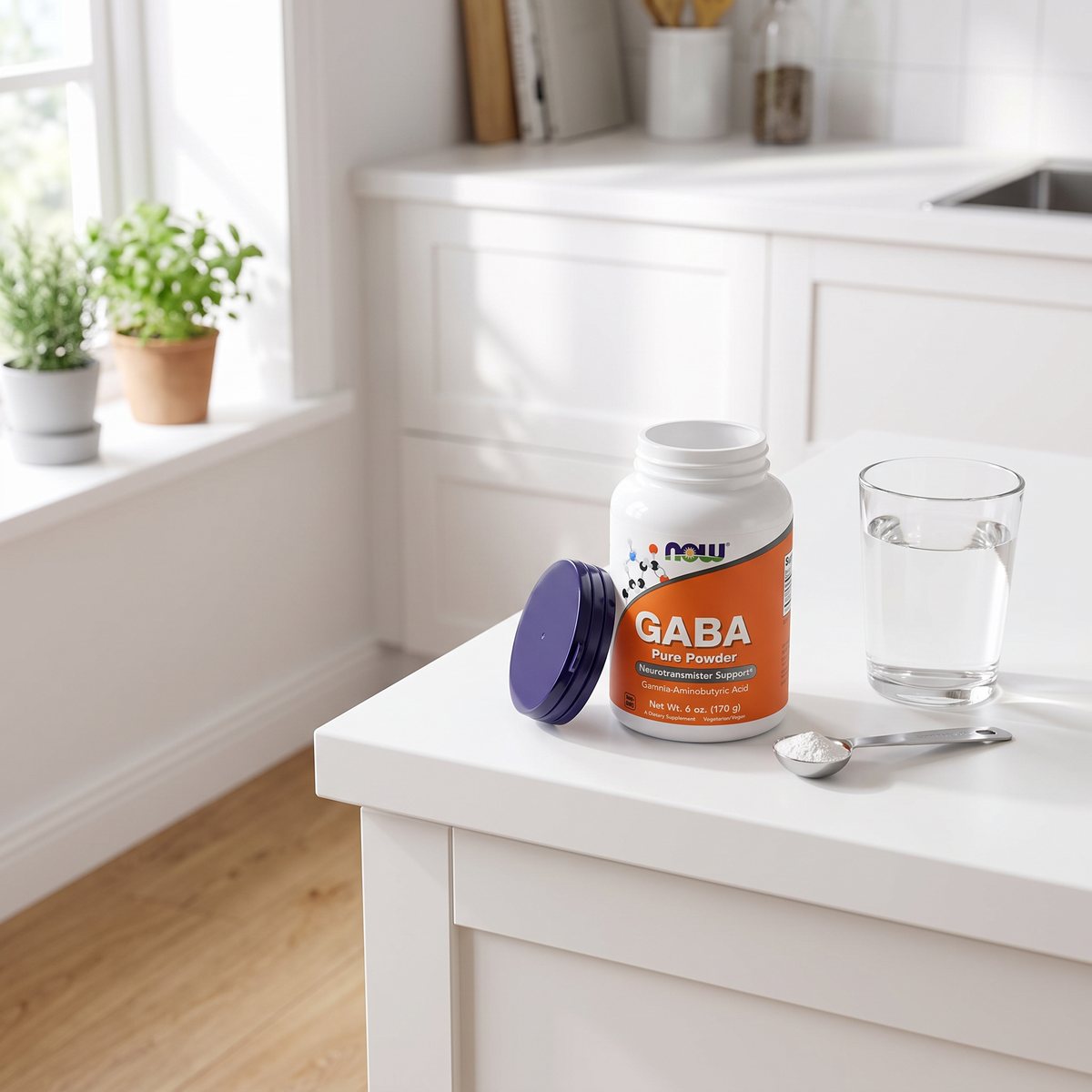 NOW GABA Pure Powder-burken öppen på en vit bänkskiva i ett ljust svenskt kök med en mätsked pulver och ett glas vatten