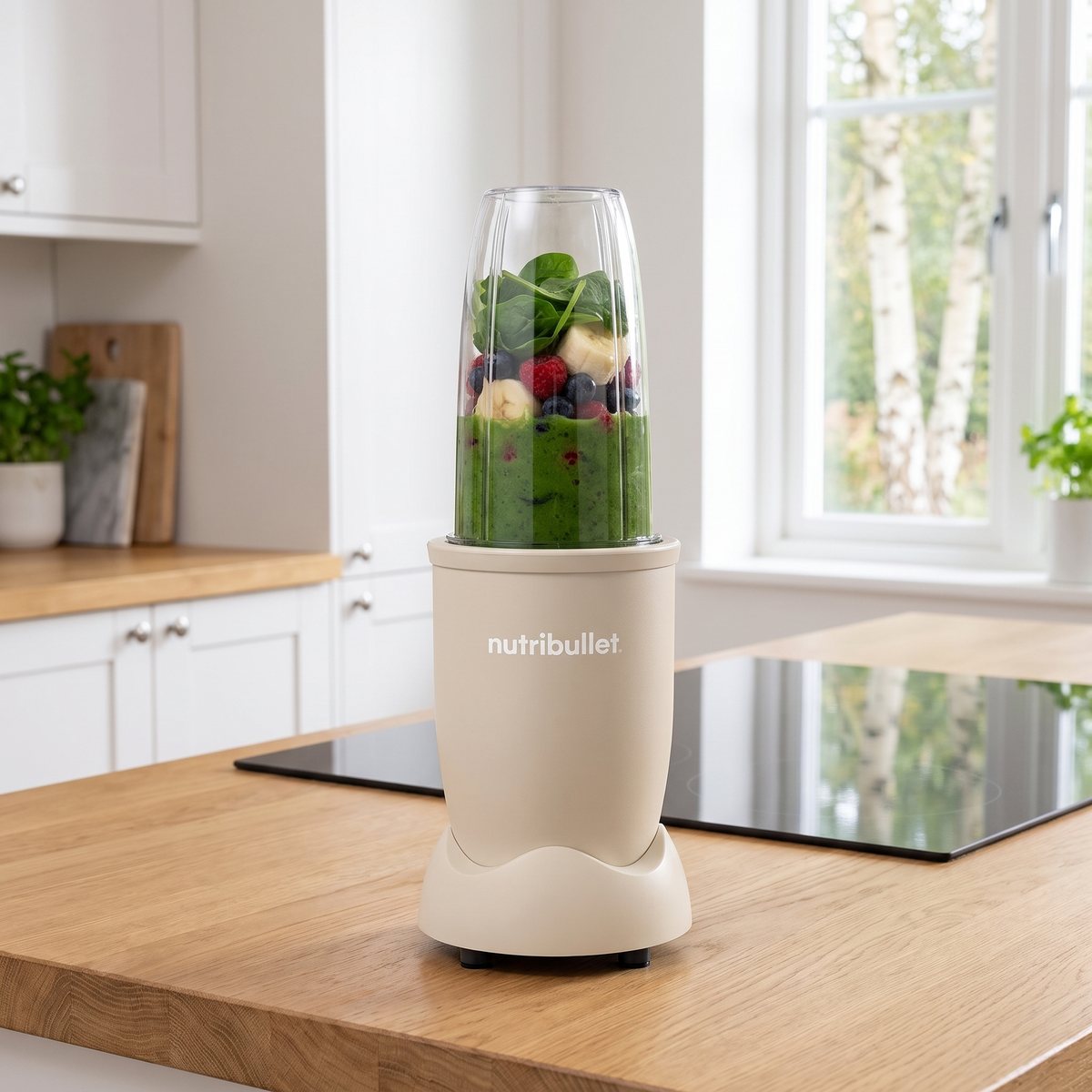Nutribullet Pro 900 i beige står på en ekbänkskiva i ett svenskt kök med en grön smoothie i bägaren