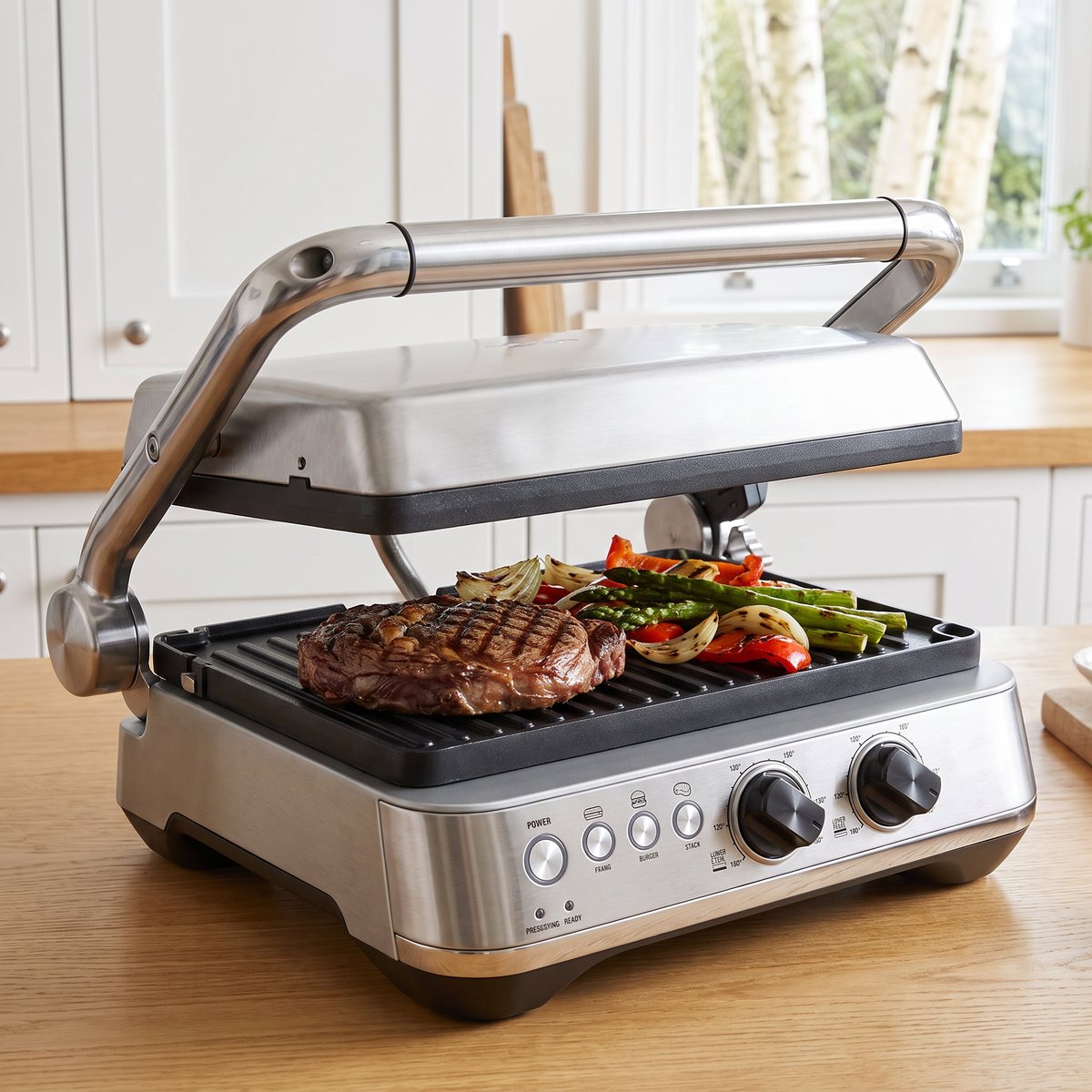 Sage SGR700 The BBQ & Press Grill uppfälld på en köksbänk i ett svenskt kök med en grillad biff och grönsaker på nedre plattan