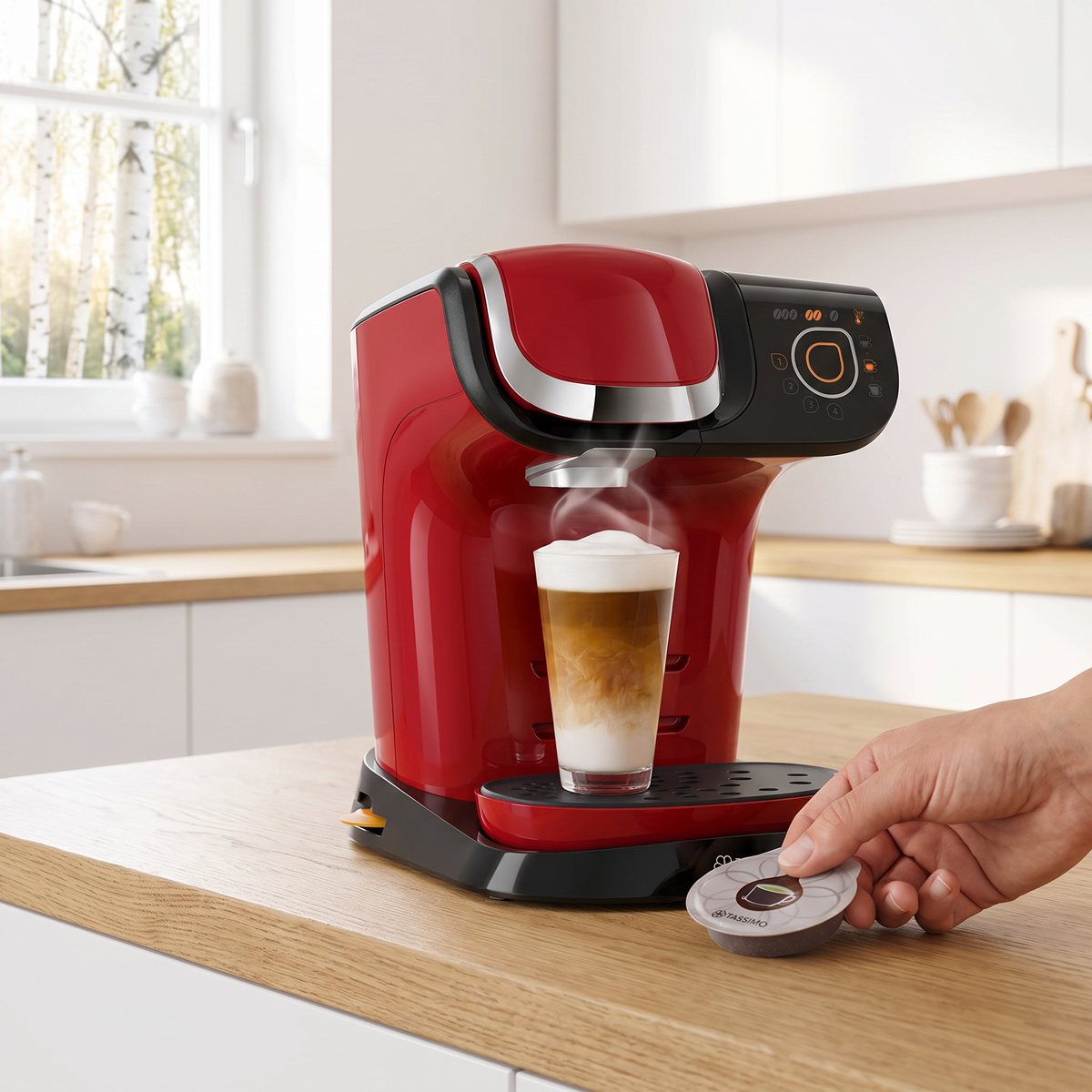 Röd Bosch Tassimo My Way 2 som brygger en latte macchiato på en ekbänk i ett ljust svenskt kök med björkar utanför fönstret