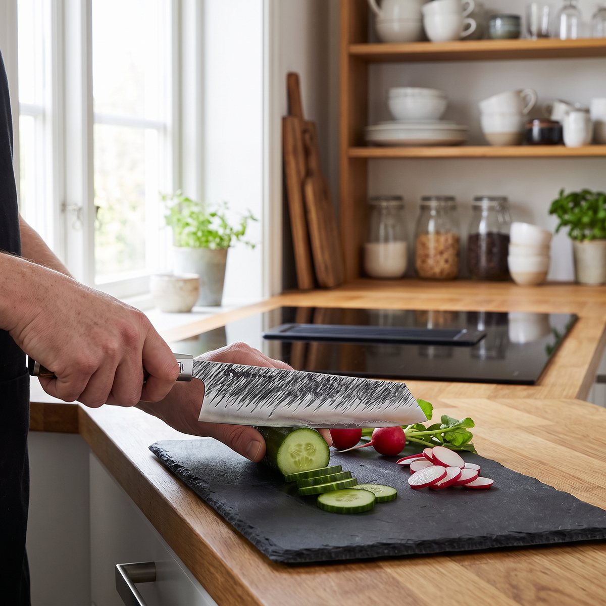 Satake Ame kiritsuke bredvid skivad gurka och rädisor på en skiffertavla i ett svenskt kök