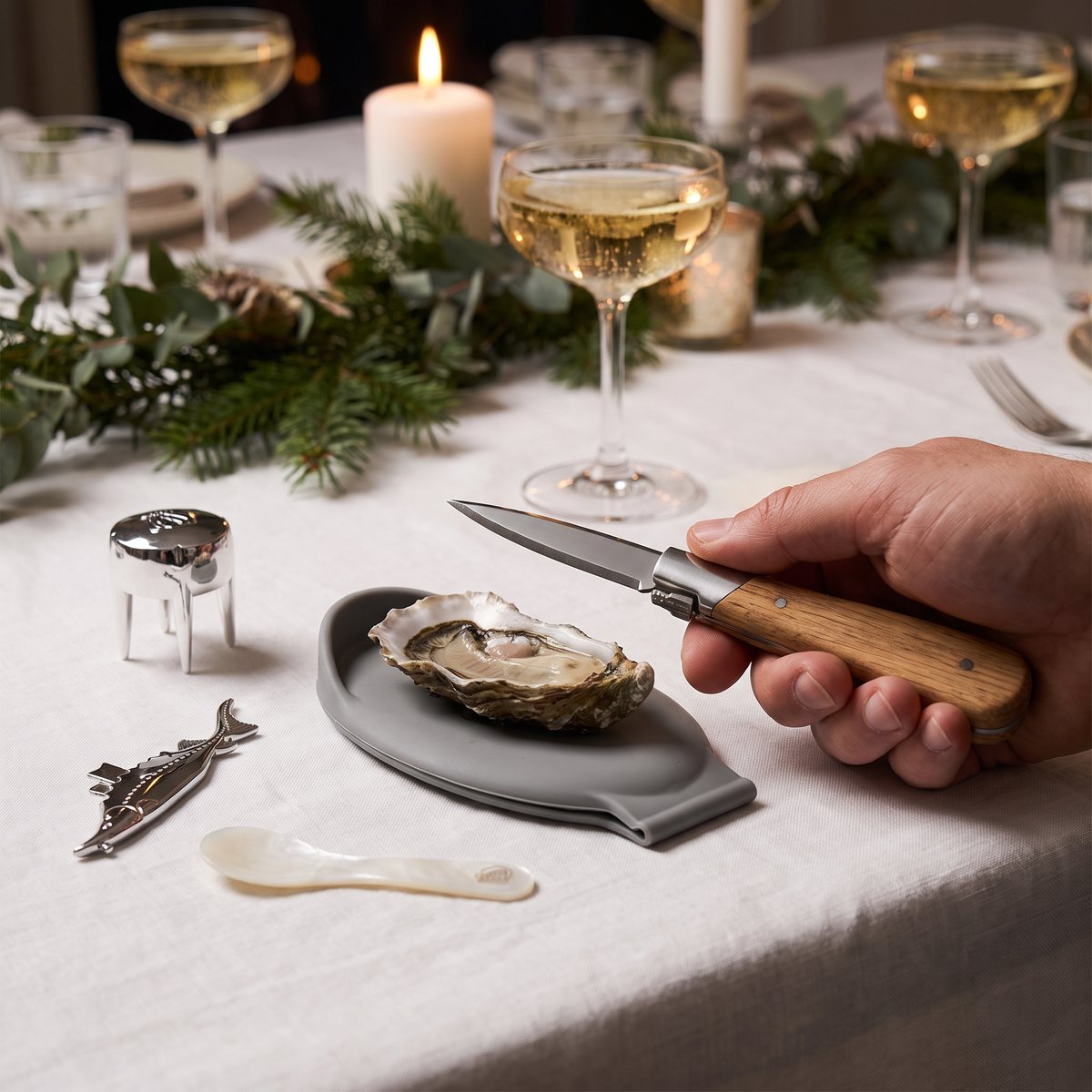 Laguiole presentset med ostronkniv i ekträ, silikonhållare, champagneöppnare och kaviarsked på ett dukat julbord i ett svenskt hem