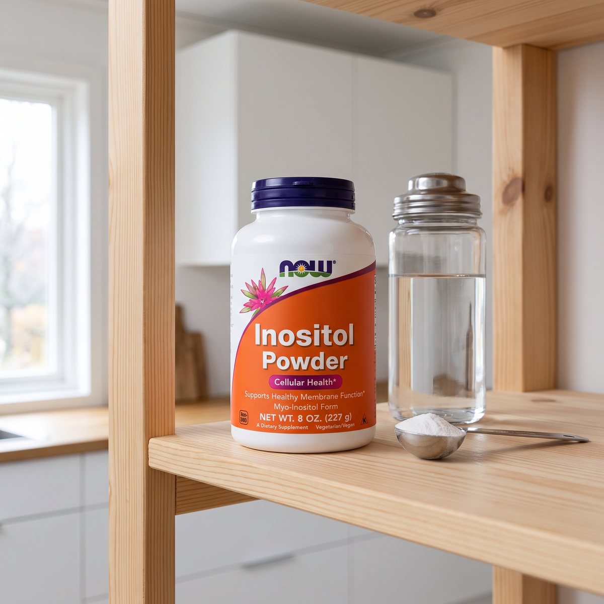 NOW Inositol Pulver i burk bredvid ett glas vatten och en mätsked i ett ljust svenskt kök