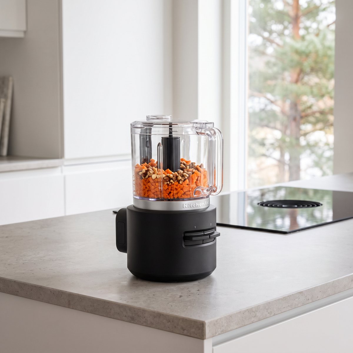 KitchenAid Go sladdlös hackare på en stenbänk i ett svenskt kök med hackade morötter och nötter