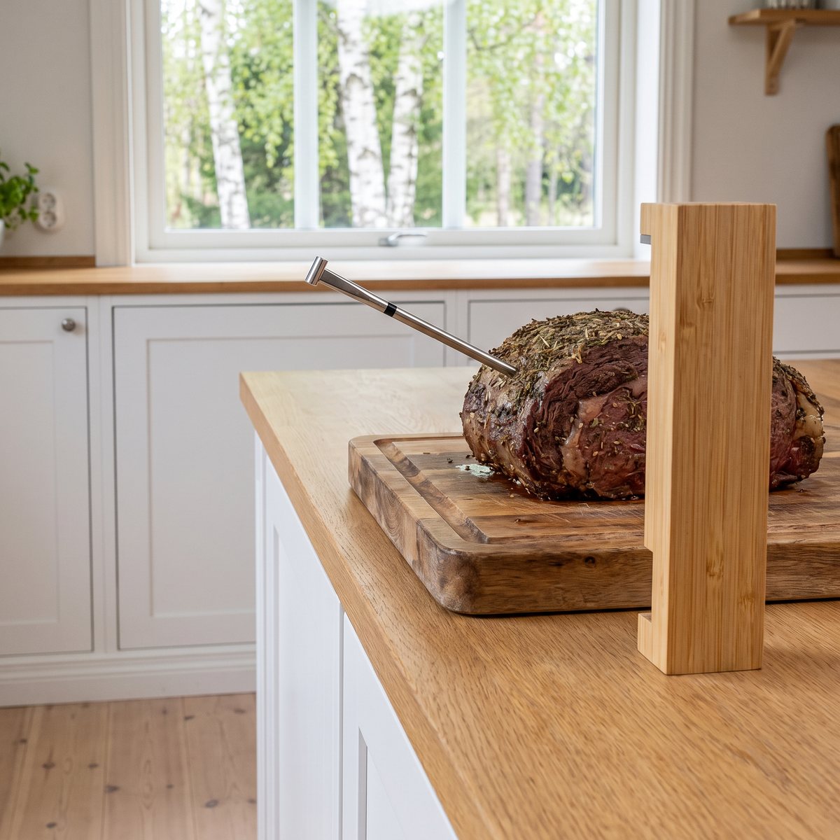 Meater Pro trådlös köttermometer med bambuladdare vid en rostbiff på skärbräda i ett svenskt kök