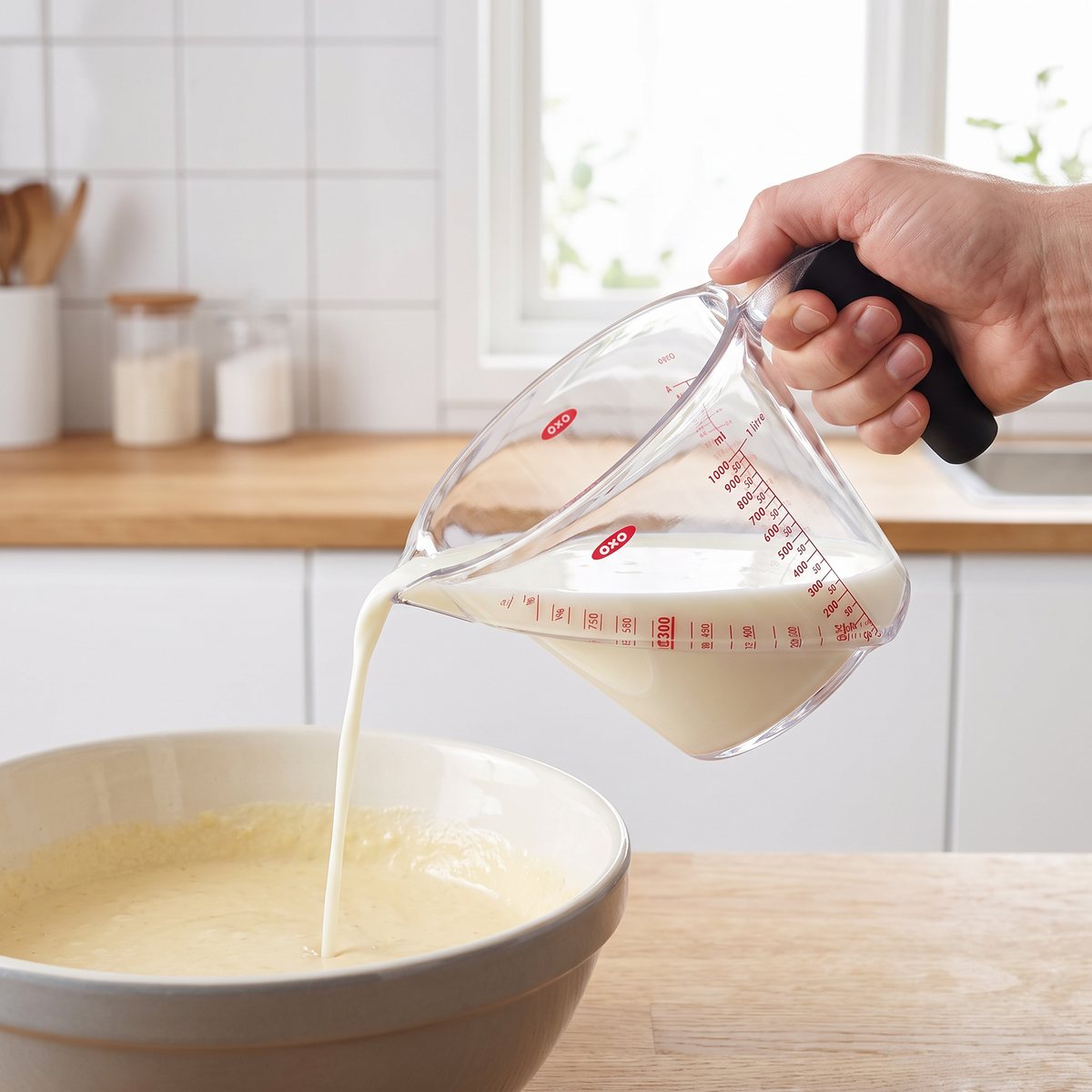 Oxo Good Grips måttbägare med mjölk som hälls i en bunke med pannkakssmet i ett ljust svenskt kök