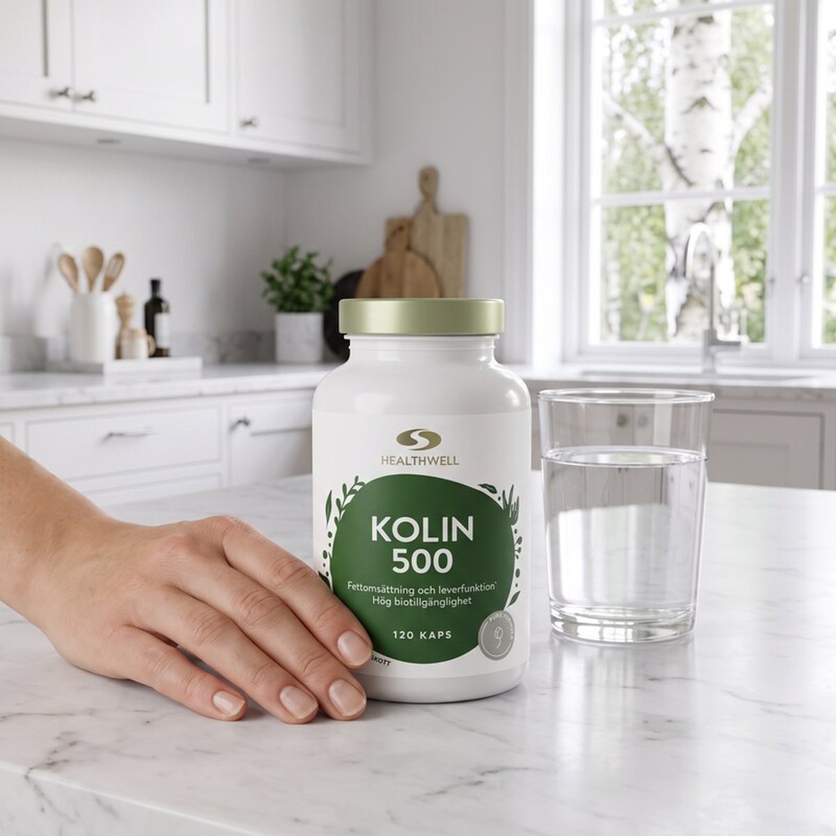 Healthwell Kolin 500 på en marmorbänk i ett ljust svenskt kök med ett glas vatten och björk utanför fönstret