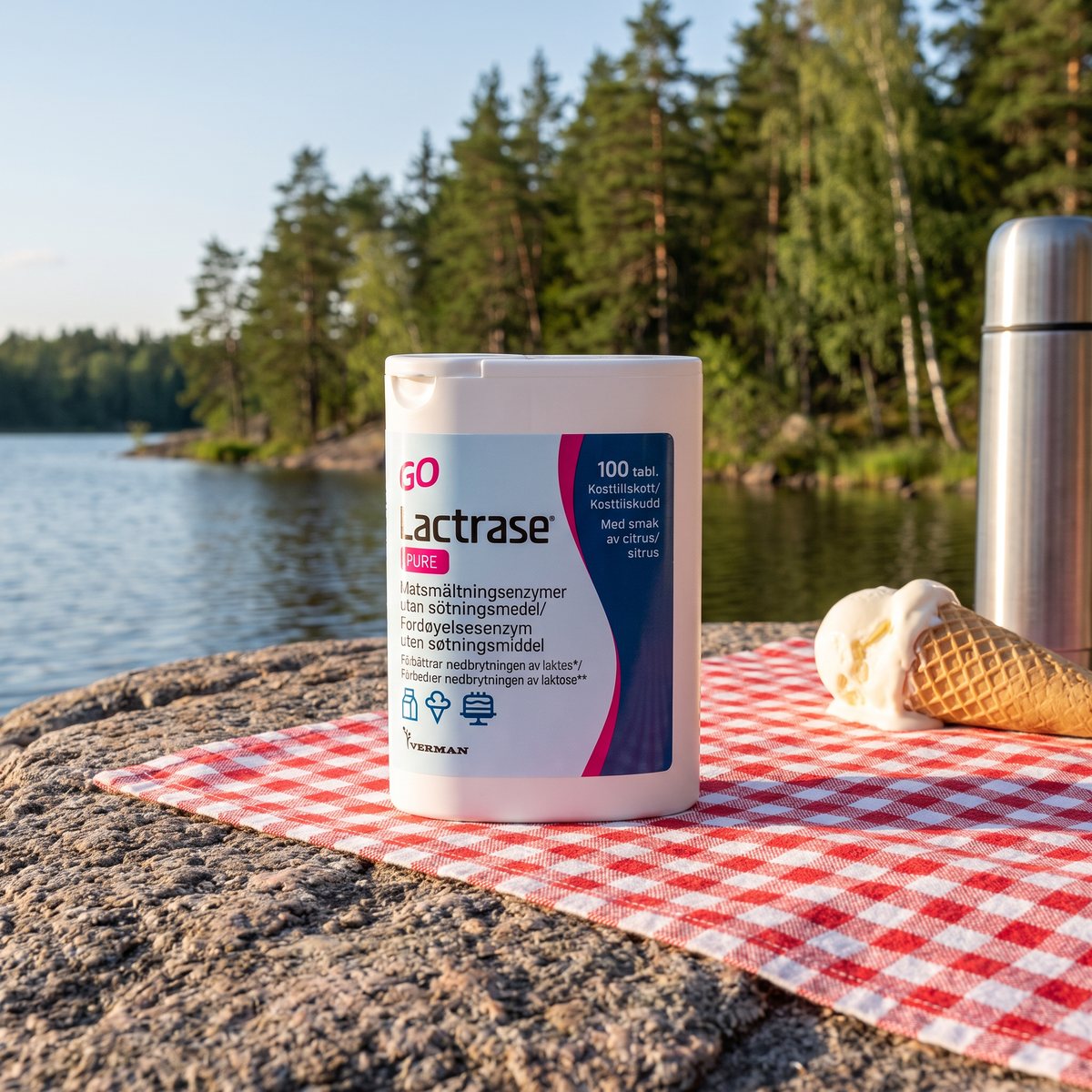Lactrase Pure-dosan på en filt vid en svensk sjö med glass och termos
