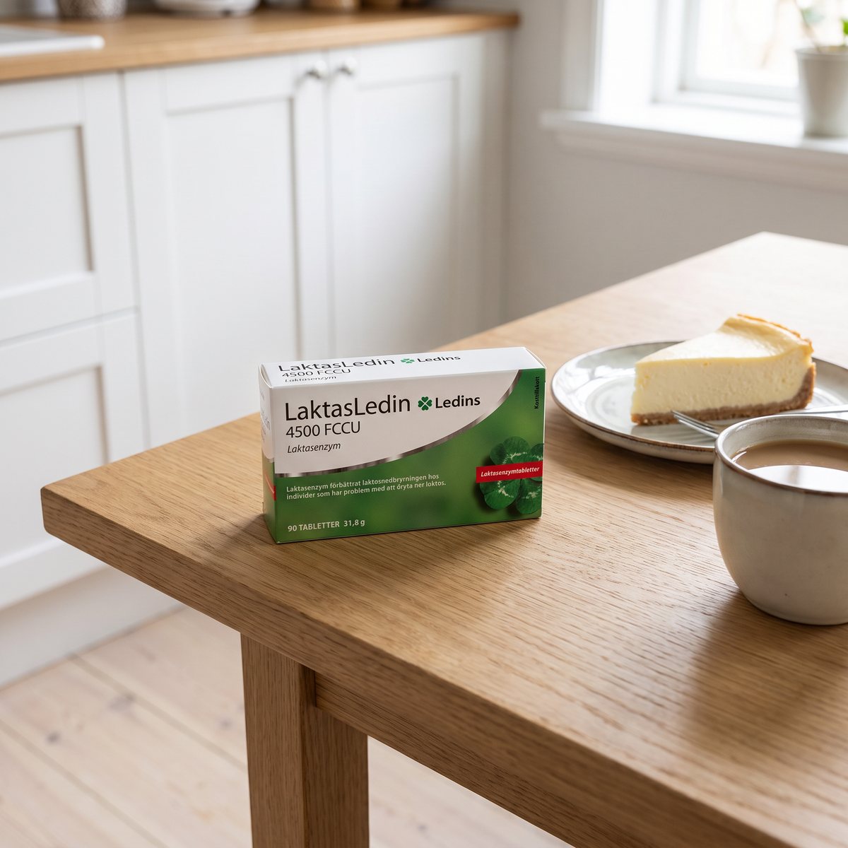Förpackningen LaktasLedin på ett svenskt köksbord med ostkaka och kaffe