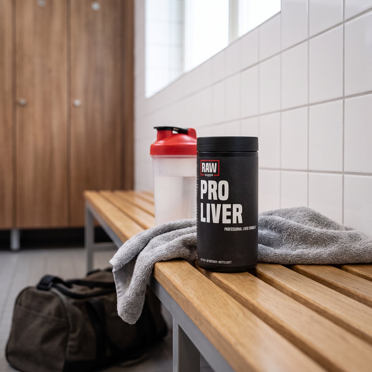 RAW Pro Liver-burken på en träbänk i ett svenskt gym med shaker och handduk