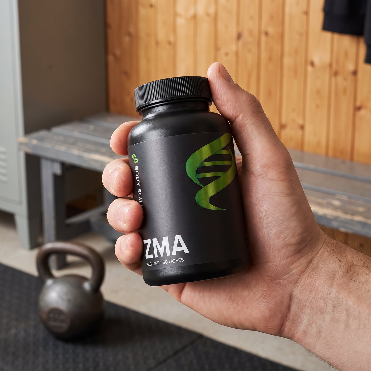 Hand som håller en svart Body Science ZMA-burk i ett svenskt hemmagym