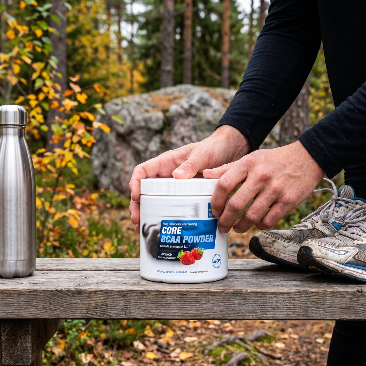 Burk med Core BCAA Powder på en träbänk i svensk tallskog med vattenflaska och löparskor