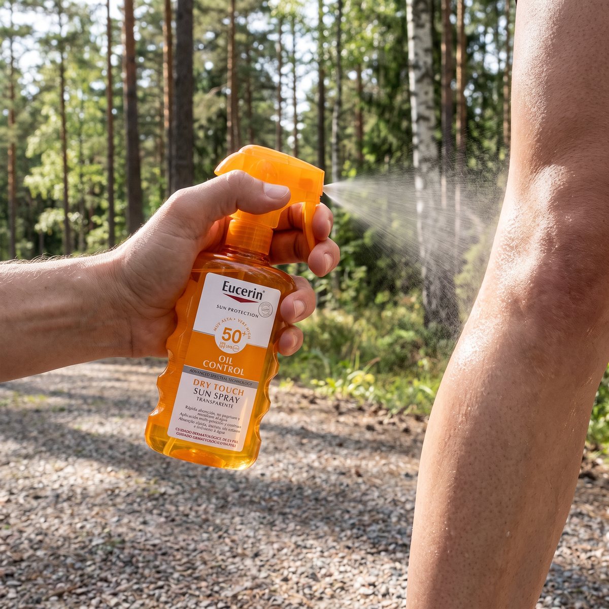 Eucerin Sun Spray Transparent som sprayas på ett ben vid ett löpspår i svensk tall- och björkskog