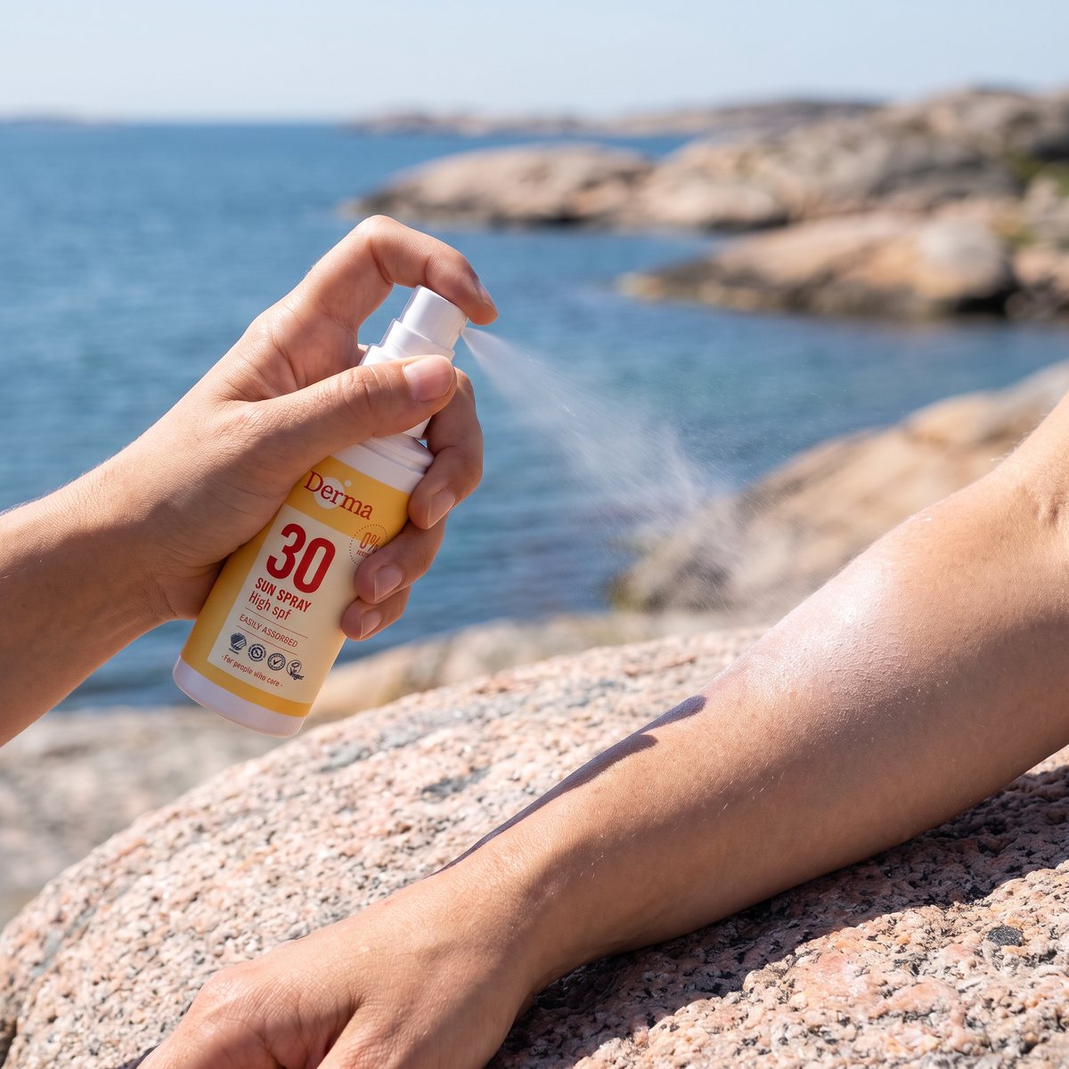 Derma Sun Spray sprayas på underarmen på en granitklippa i den svenska skärgården