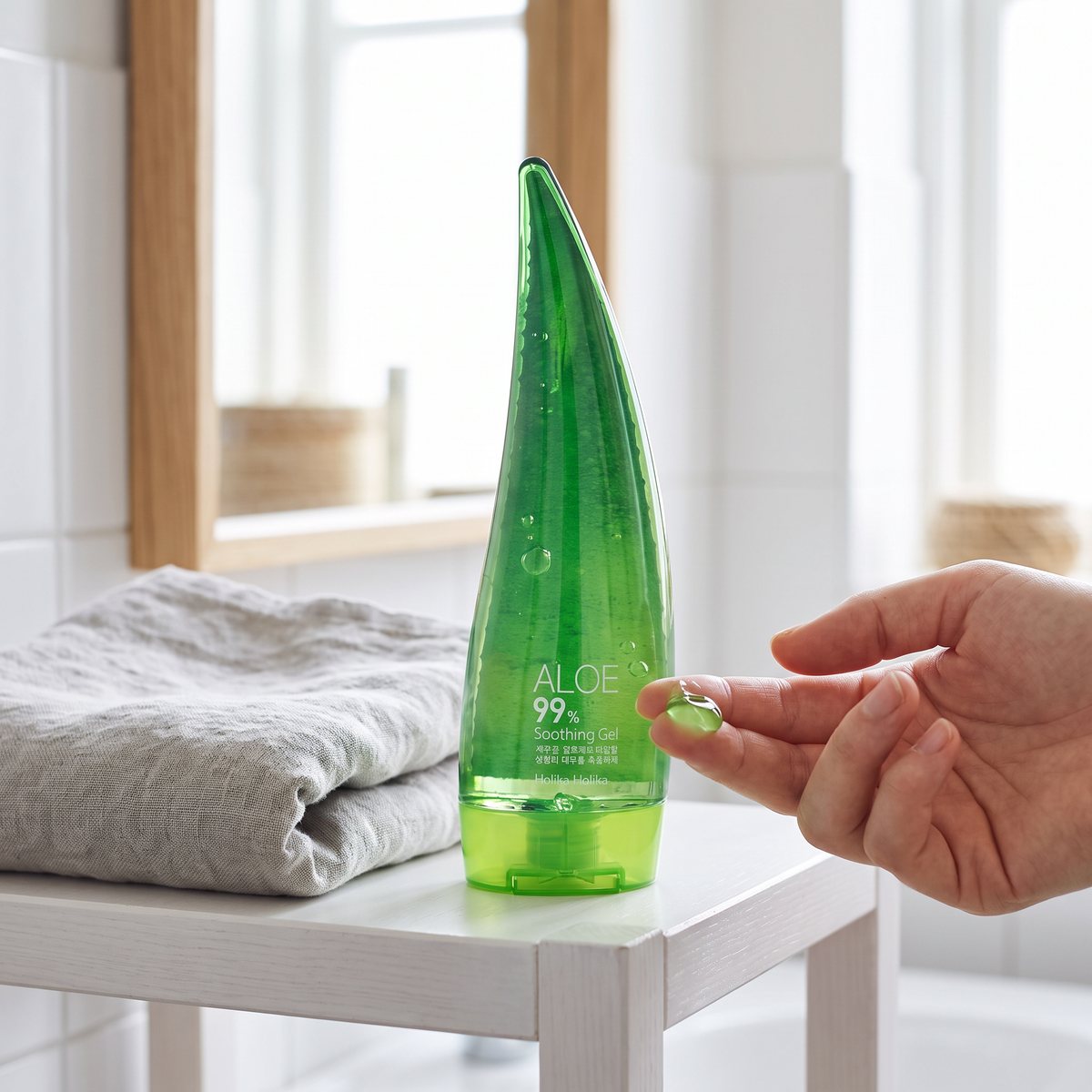 Holika Holika Aloe 99% Soothing Gel i flaska på en badrumshylla med linnehandduk i en svensk lägenhet