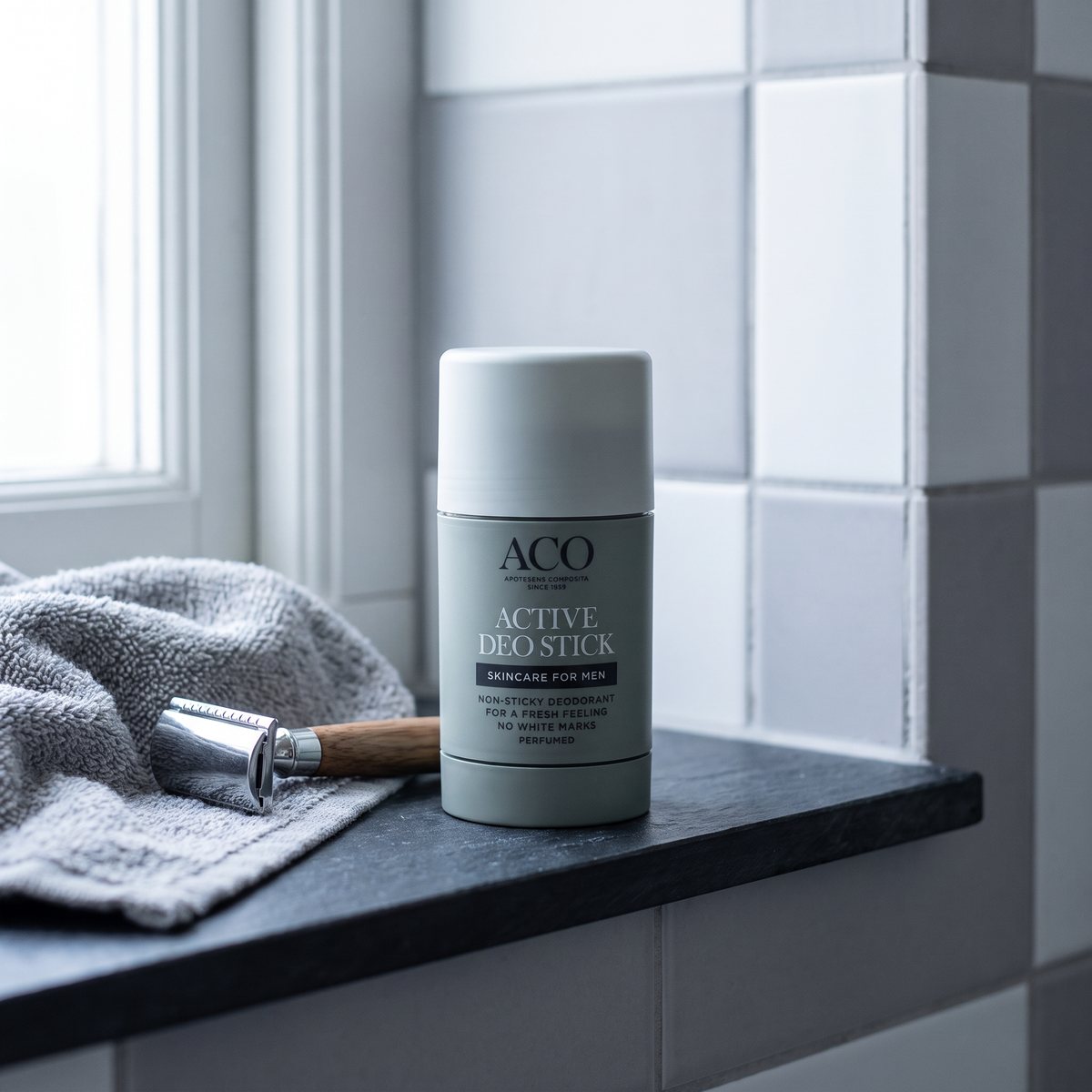 ACO for Men Active Deostick på en skifferhylla i ett svenskt badrum bredvid rakhyvel och handduk