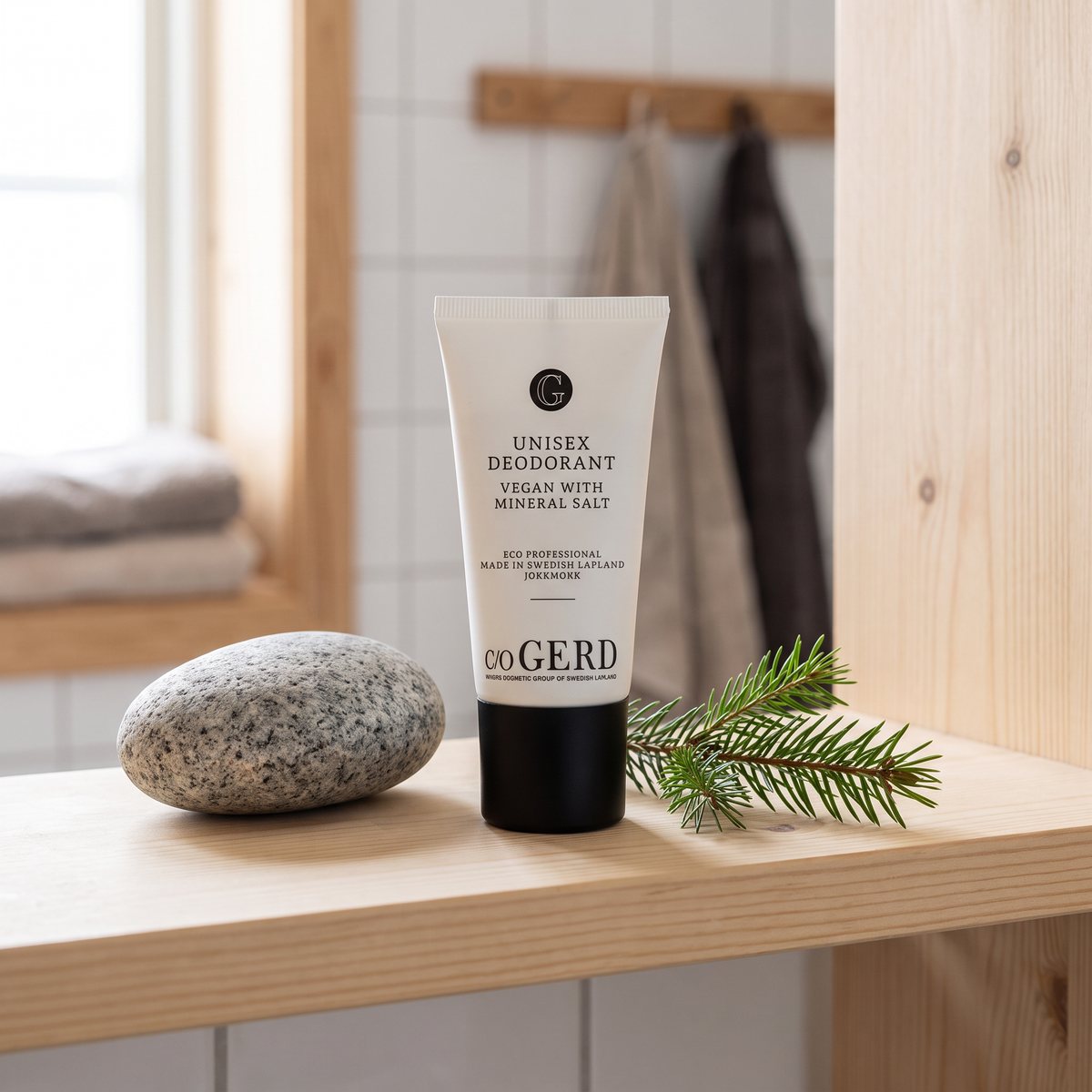 c/o Gerd Unisex Deodorant i tub på en furuhylla bredvid en granitsten och en granruska i ett svenskt hem