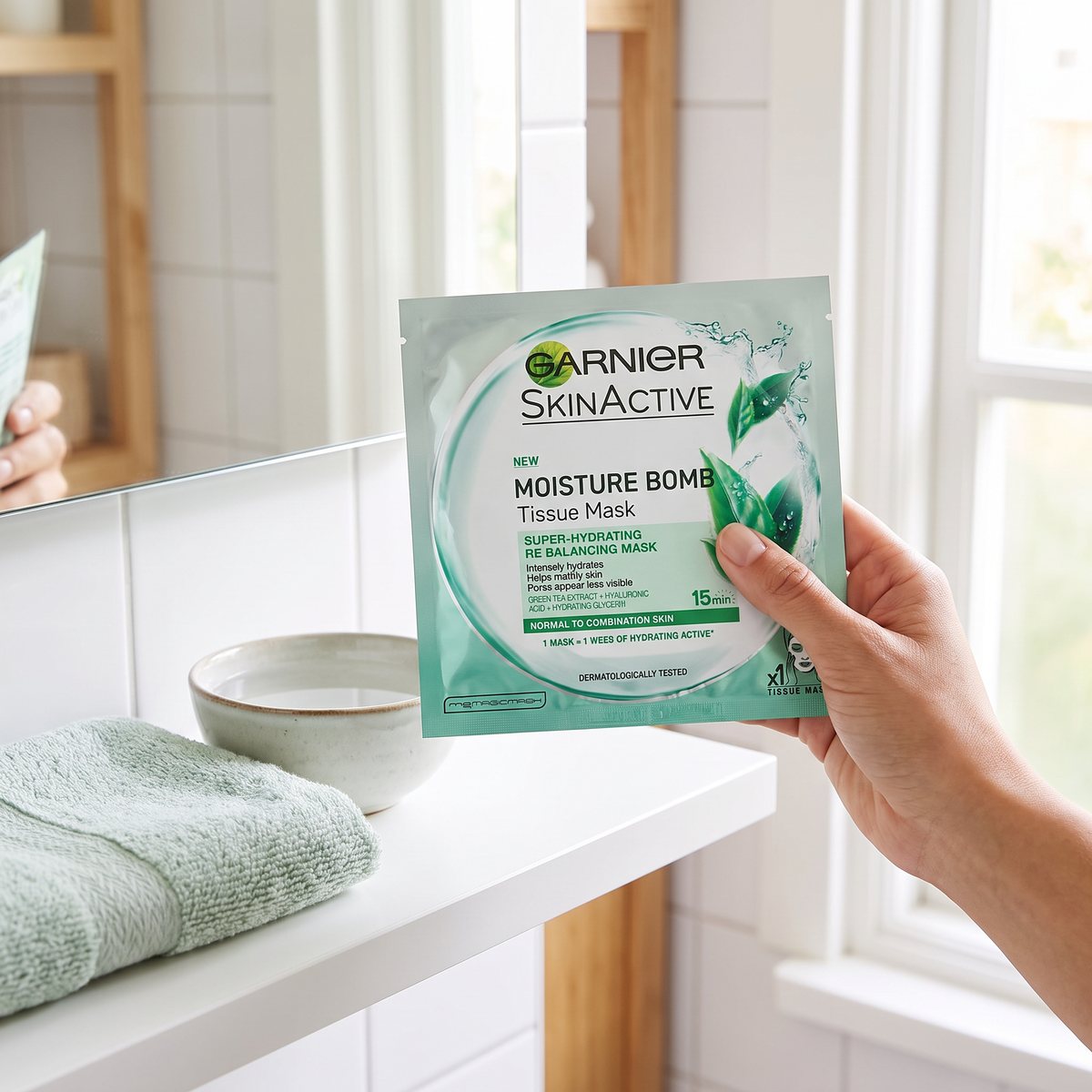 Garnier Moisture Bomb Tissue Mask Green hållen i handen vid en badrumshylla i en svensk bostad