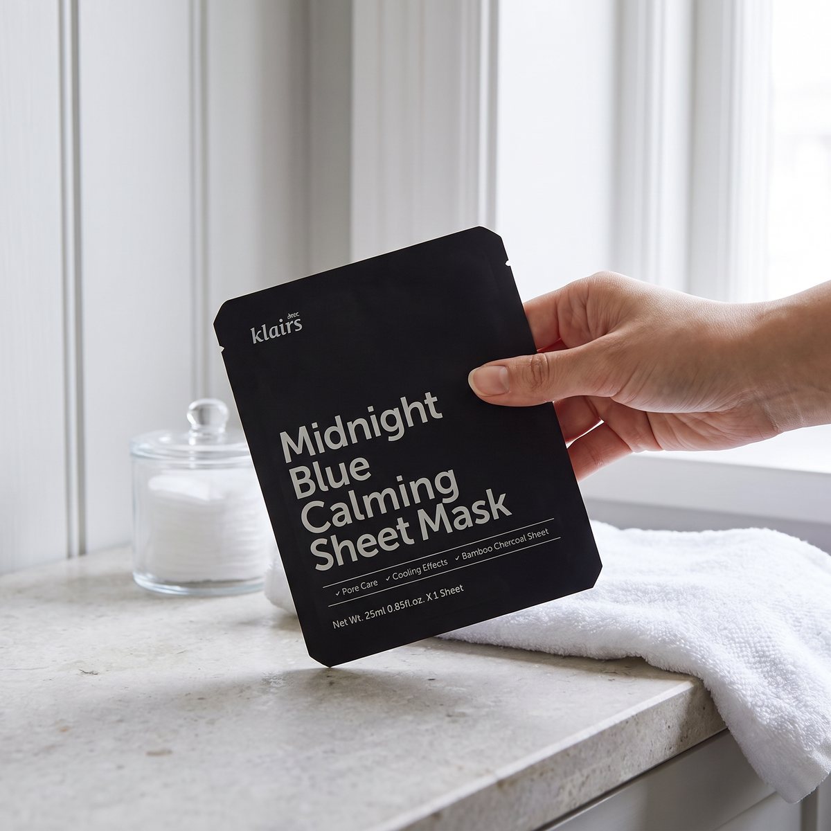 Svart Klairs Midnight Blue Calming Sheet Mask-påse på en stenbänk i ett svenskt badrum