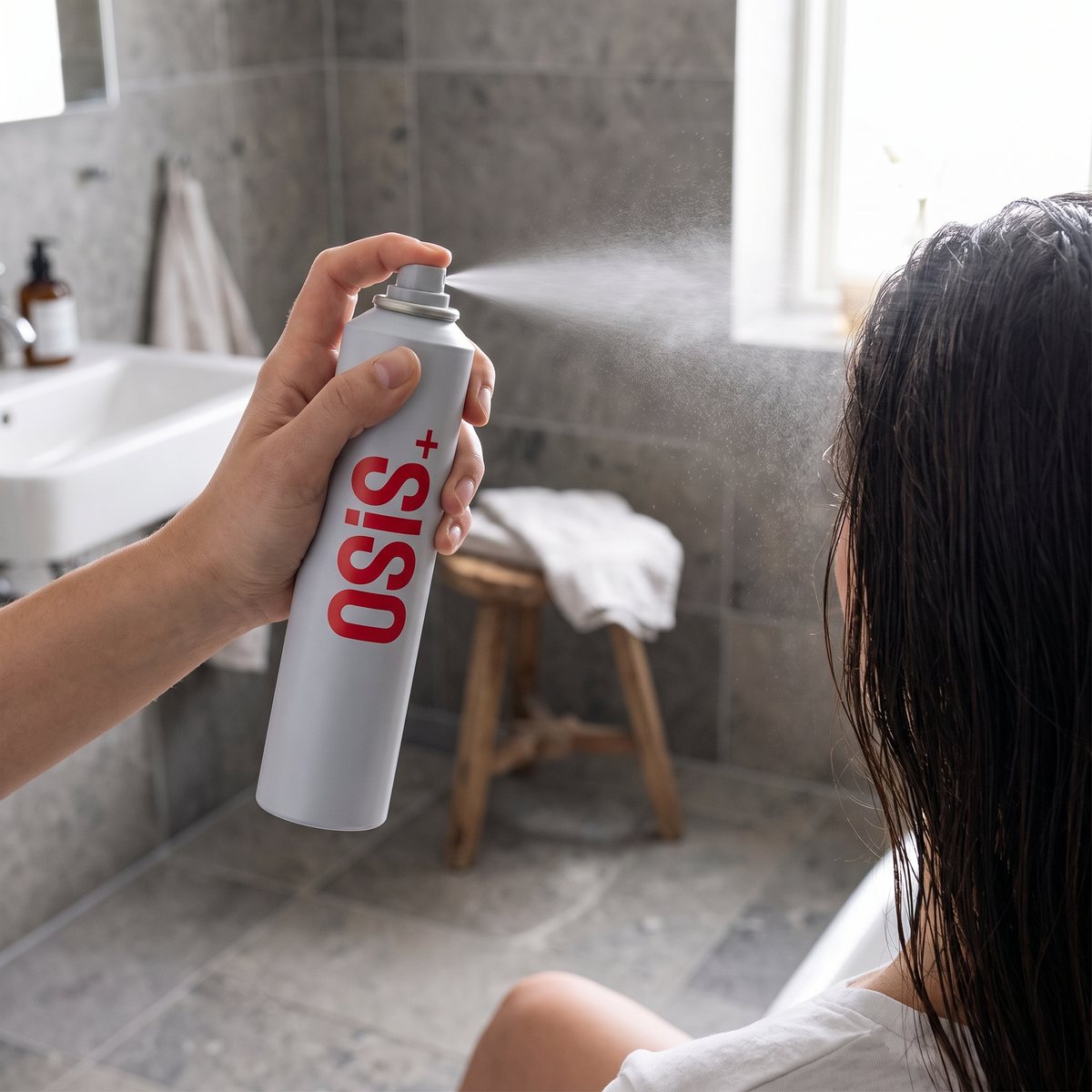 Schwarzkopf Osis+ Freeze Pump sprayas på fuktigt hår i ett svenskt badrum med grå kakelplattor