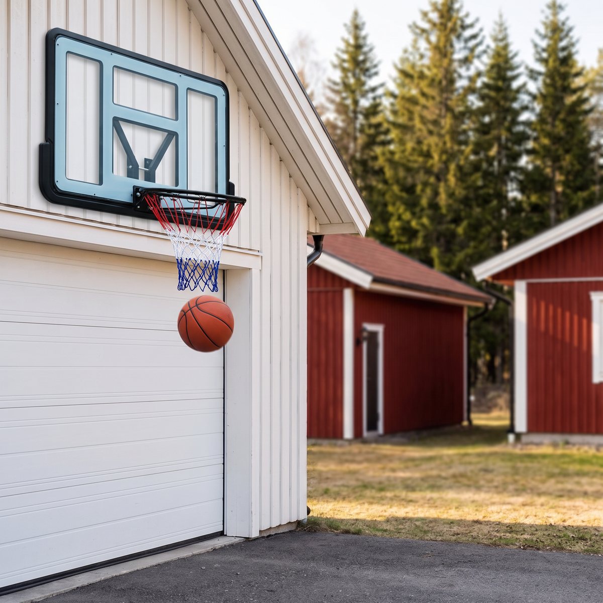 Trekkrunner Dunk Shot väggkorg monterad på en vit garagevägg ovanför garageporten, med en boll på väg genom nätet.