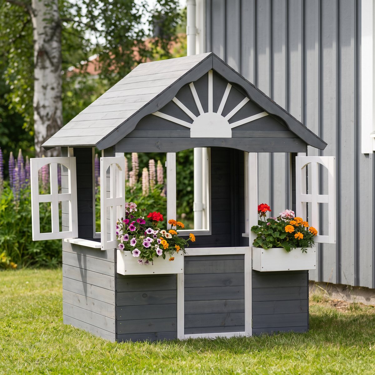 Lyfco lekstuga i grått och vitt med öppna fönster och blommor i blomlådorna, bredvid en grå husfasad och lupiner