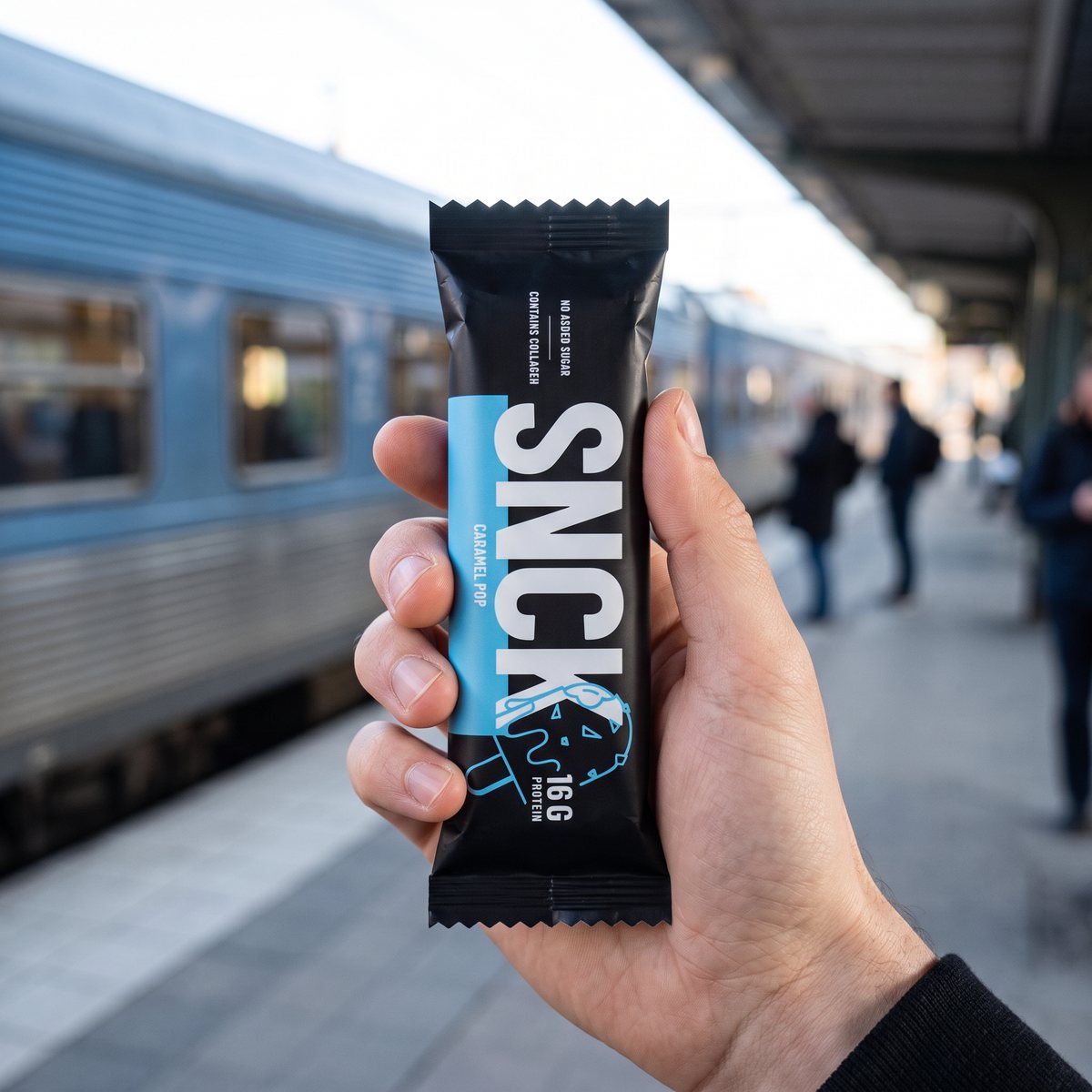 Svart proteinbar hålls i handen på en svensk tågperrong en morgon