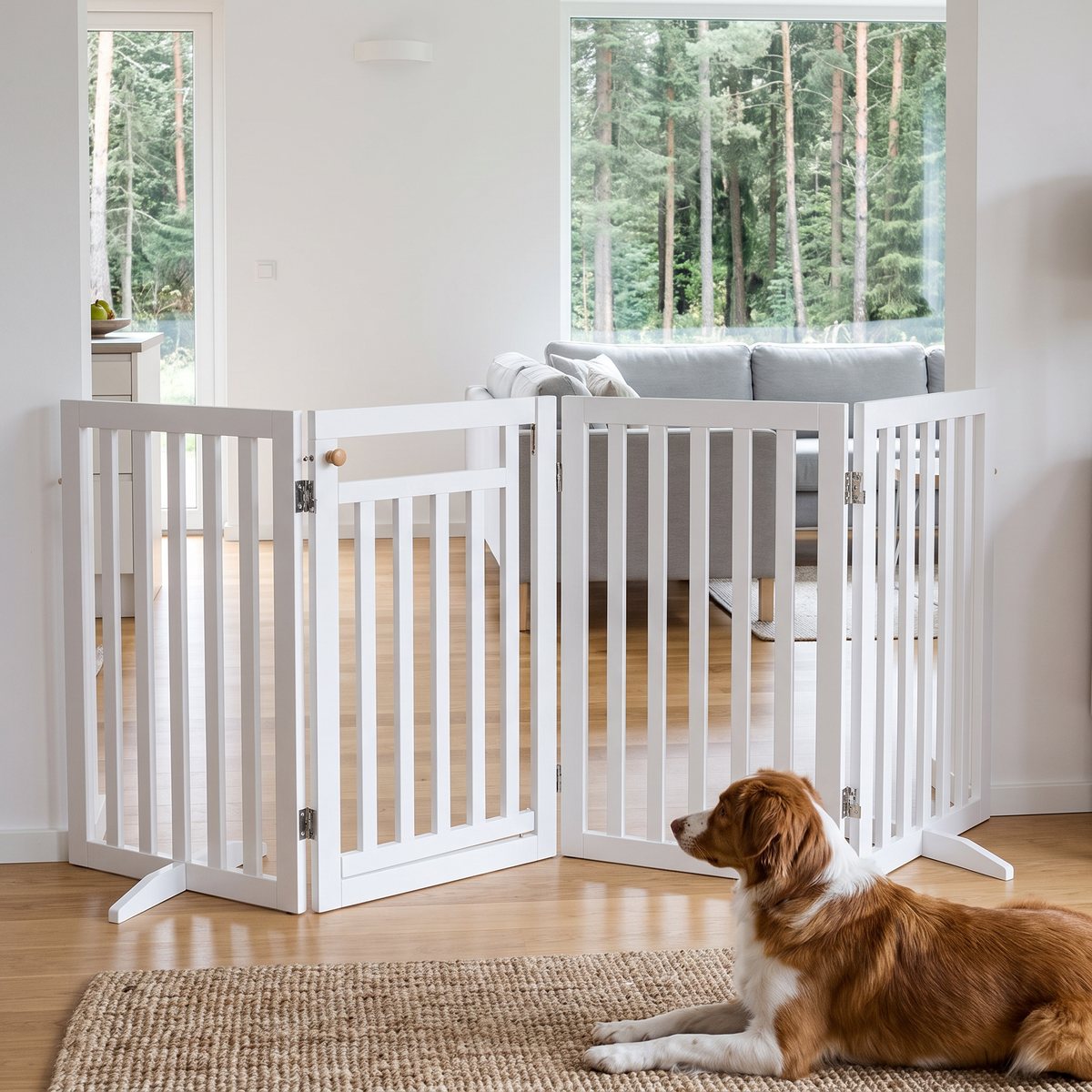 Vit fristående Trixie hundgrind i fyra delar framför köksöppningen i ett ljust svenskt vardagsrum, med en hund som ligger på mattan