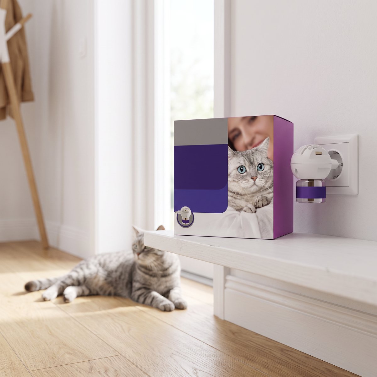 Feliway Optimum startförpackning med doftavgivare i vägguttag i en svensk hall, med en grå katt som vilar på trägolvet.